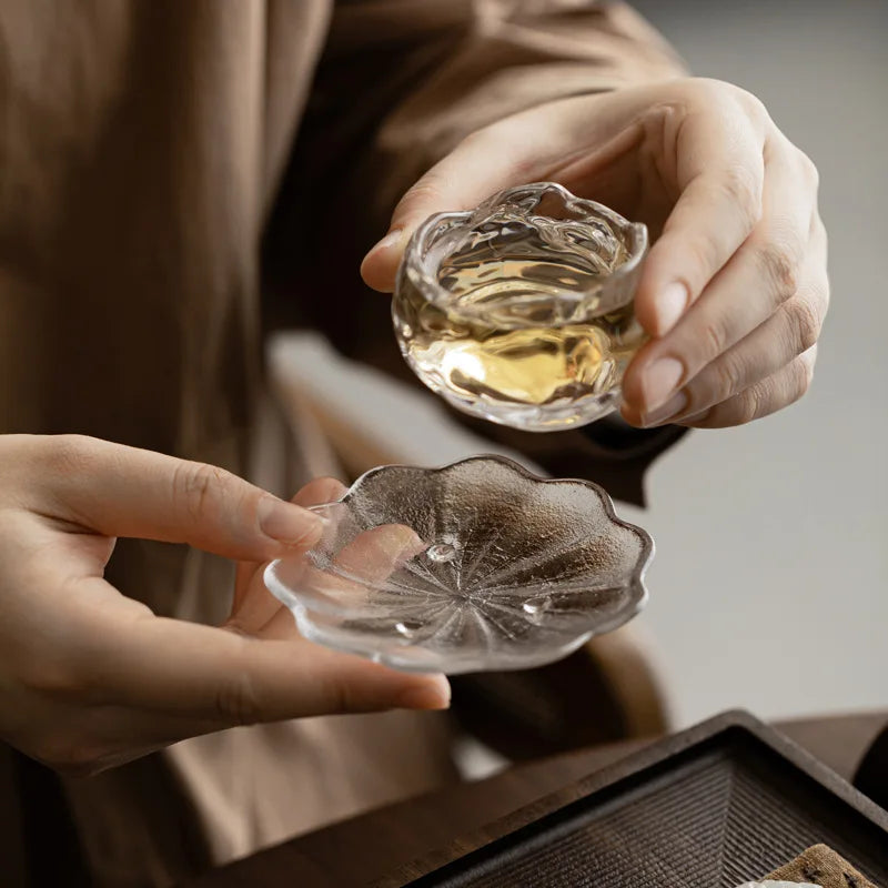 Two crystal glass coasters held in hand